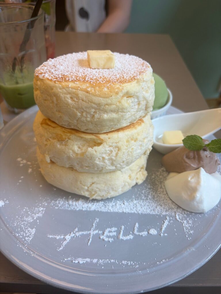 粉糖と抹茶アイスを添えた三段重ねのスフレパンケーキ